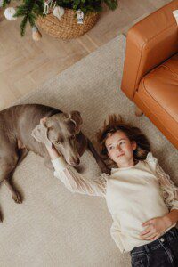 Girl on carpet with her dog after using a hired carpet cleaner from IGA